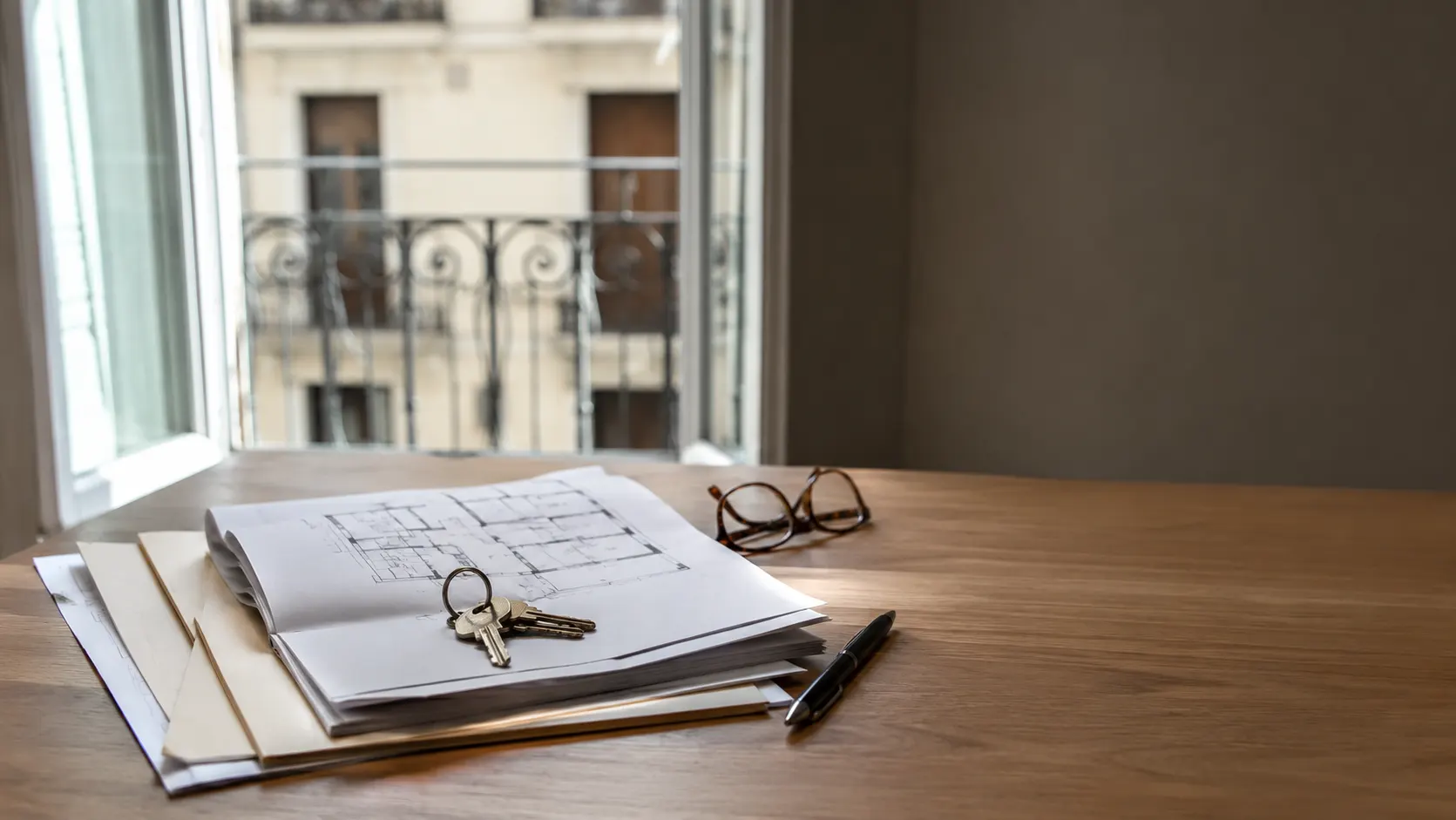 Documentos y llaves sobre una mesa al vender una vivienda en Madrid
